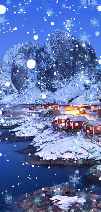 Snowy coastal village at night with blue sky and mountains backdrop.