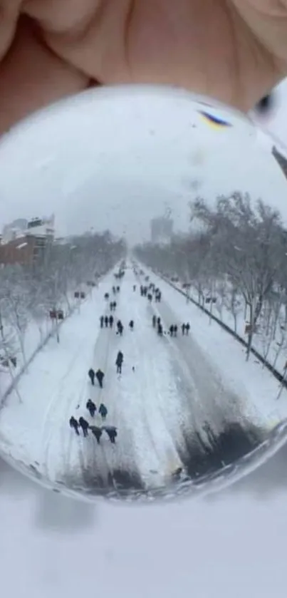 A snowy street scene viewed through a crystal globe, creating a magical winter effect.