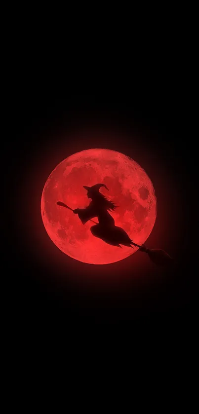 Silhouette of a witch flying across a red moon on a dark mobile wallpaper.