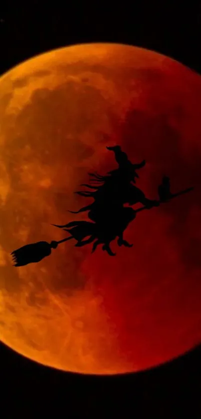 Witch on broomstick silhouetted against a crimson blood moon.