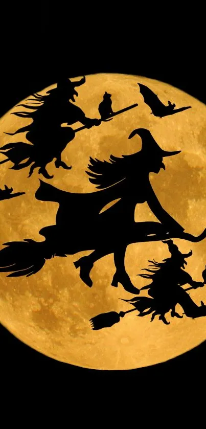 Witches flying across an orange full moon on a dark night sky.