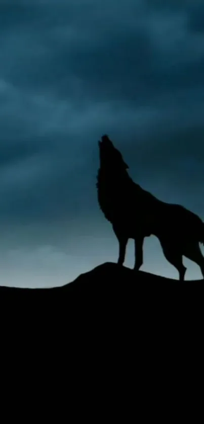 Silhouette of a howling wolf against a dark blue sky.