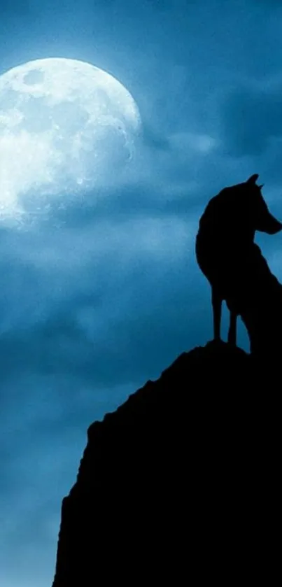 Silhouette of wolf under a full moon in a dark blue night sky.