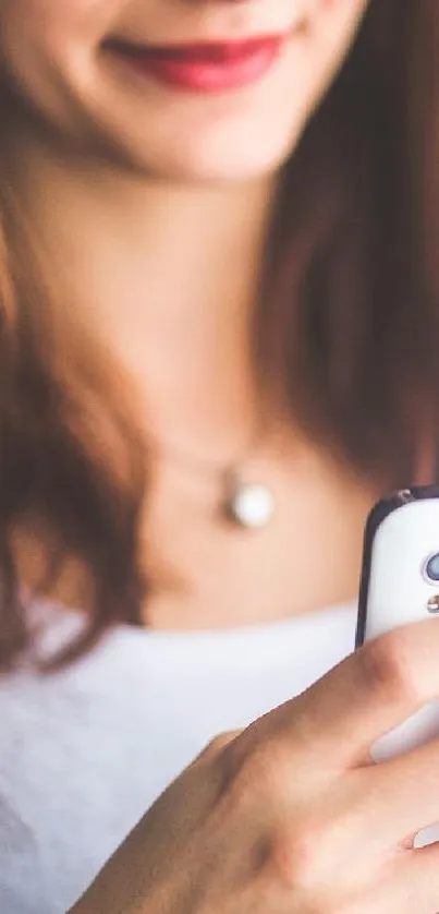 A woman holding a phone with a white background, showcasing a minimalist design.