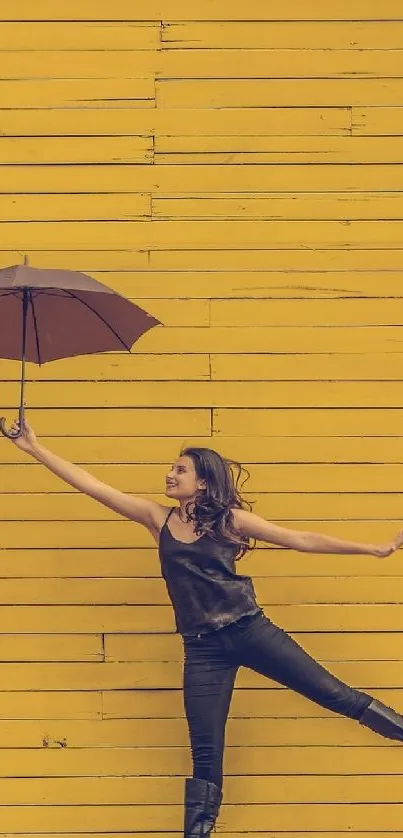 Woman with umbrella against yellow wall.