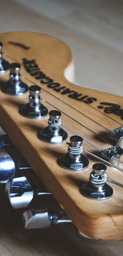 Closeup of guitar headstock with strings and tuning pegs.