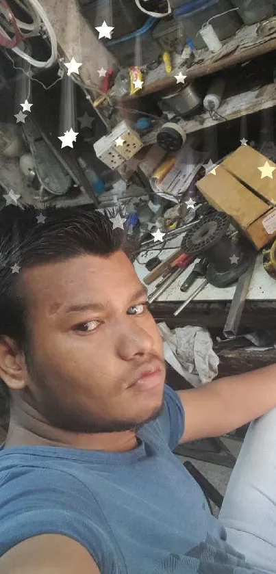 Person in blue shirt taking a selfie in a workshop environment.