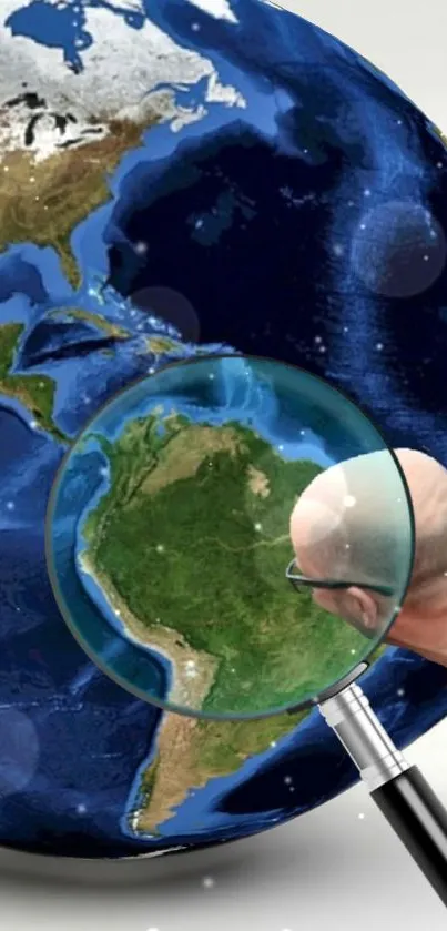 Earth seen through magnifying glass, highlighting continents on a phone wallpaper.