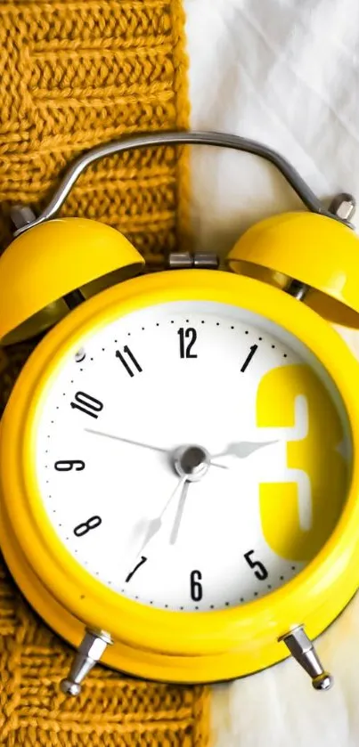 Yellow alarm clock on textured fabric background.