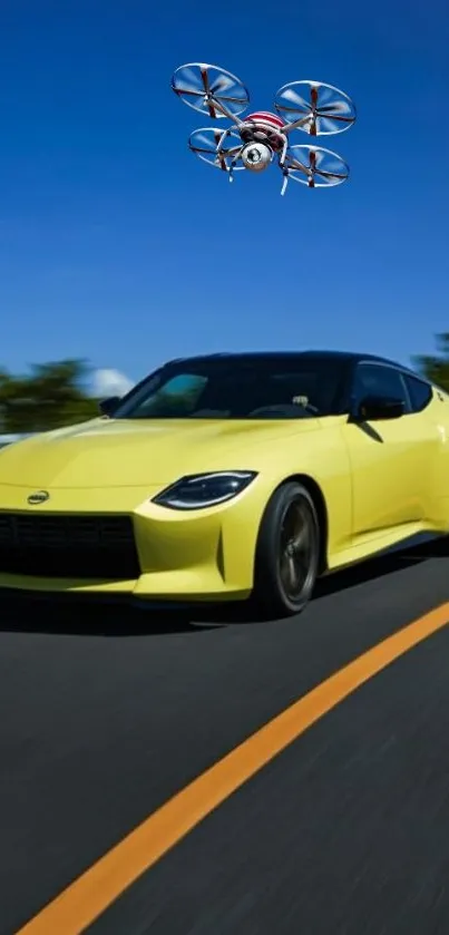 Yellow car racing under blue sky with drone overhead.