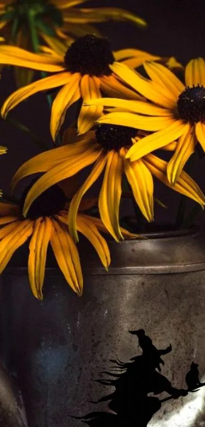 Yellow flowers in a metal vase with a witch silhouette.