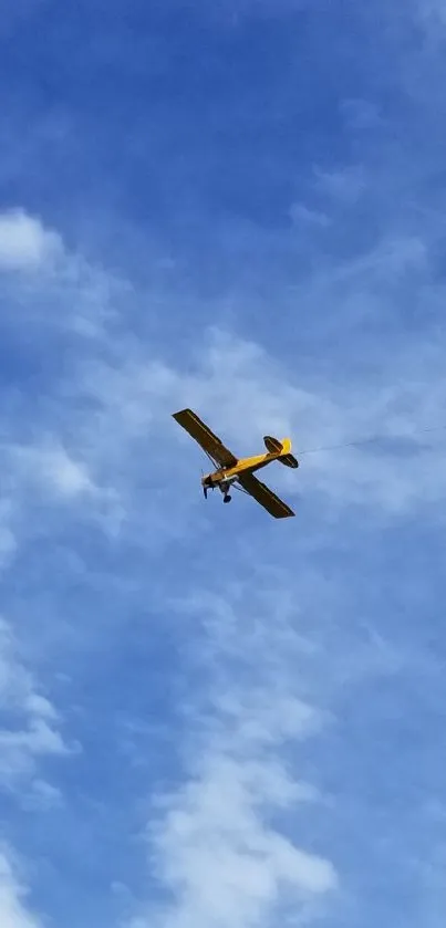 Wallpaper of a yellow airplane in a bright blue cloudy sky.