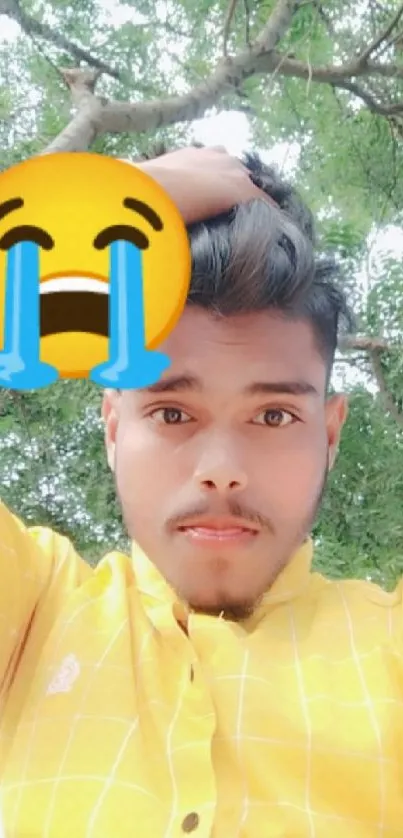 Selfie with yellow shirt and crying emoji in nature.