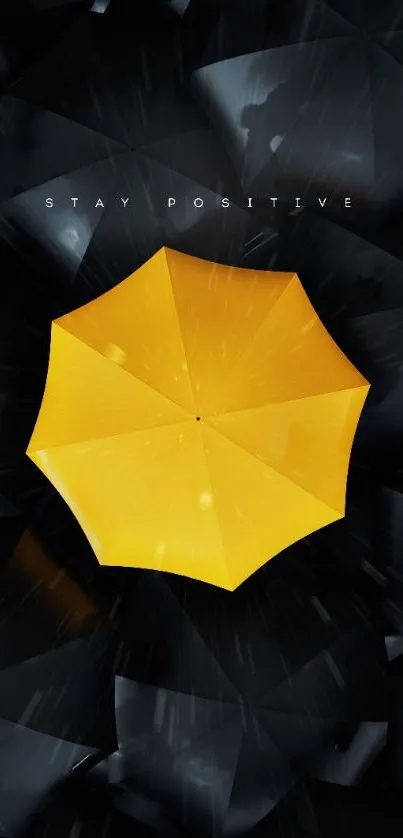 Yellow umbrella on dark backdrop, stay positive message.