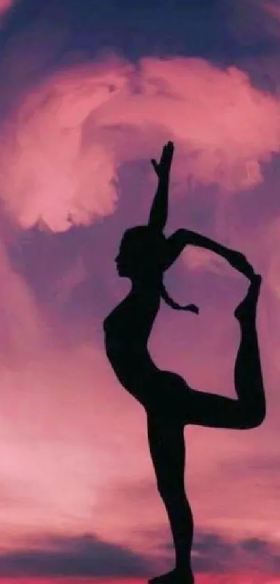 Silhouette of yoga pose against a pink sunset sky.