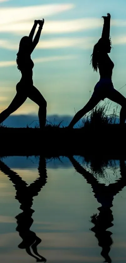 Two figures doing yoga in silhouette against a sunset with reflection.