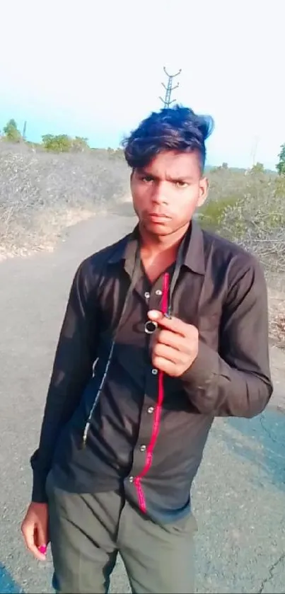 Young man standing on a scenic pathway showing style.