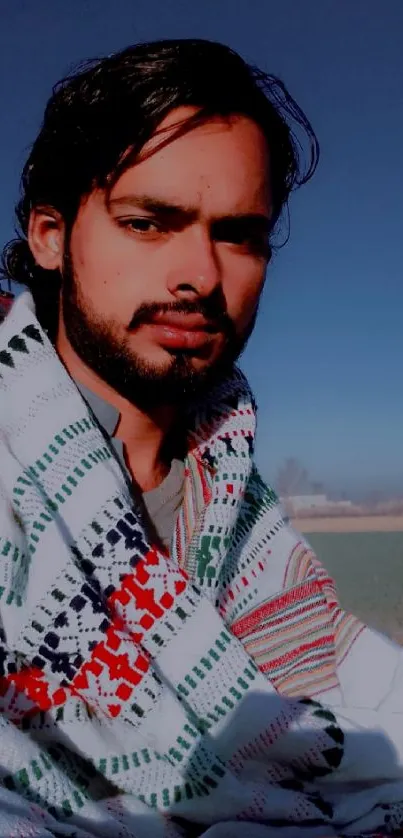 Young man in shawl under blue sky