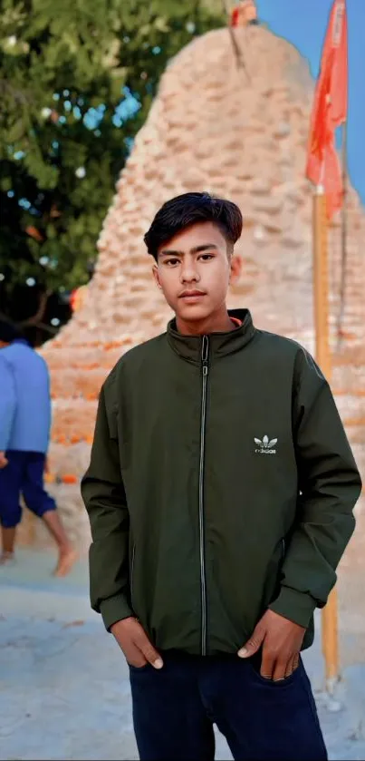 Young man in green jacket with urban backdrop.