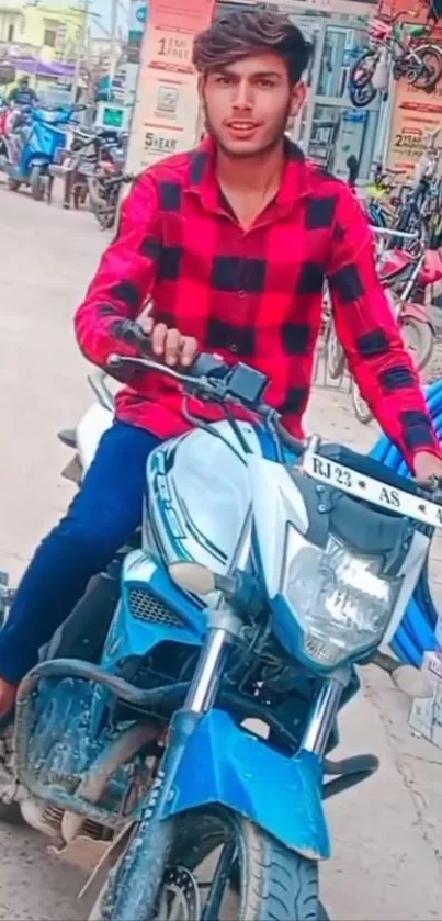 Young man riding a motorcycle on a city street.