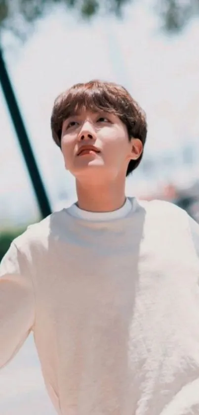 Young man gazing up under a clear blue sky.