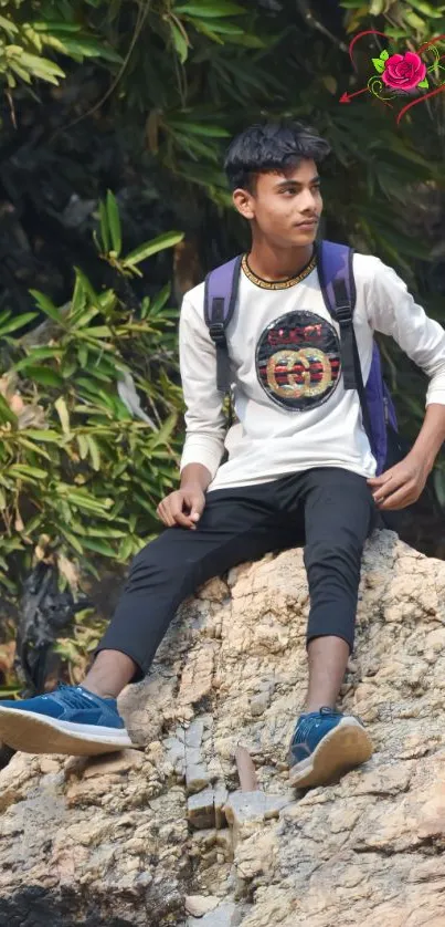 Young person sitting on rock amidst greenery.