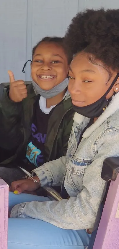 Two smiling kids enjoying a ride, exuding fun and joy.