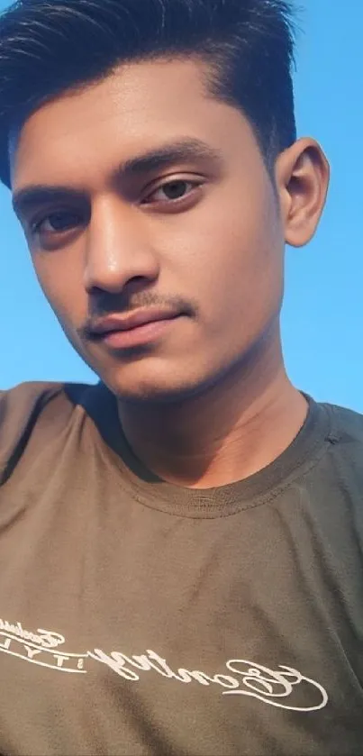 Portrait of a young man against a clear blue sky.