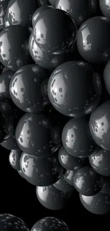 Mobile wallpaper with glossy black spheres on a dark background.