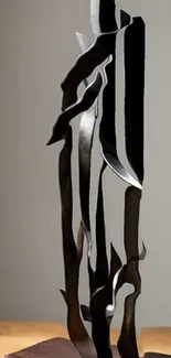 Abstract metal sculpture on neutral background.