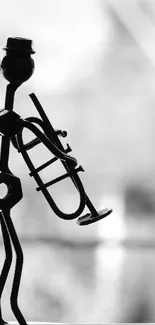 Monochrome abstract silhouette of musician with trombone on blurred background.