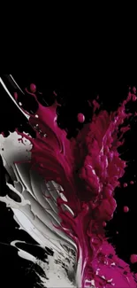 Vibrant magenta paint splash on black background wallpaper.