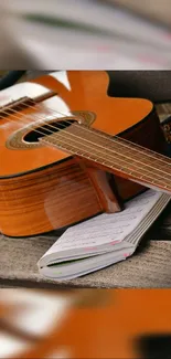 Acoustic guitar resting on an open notebook on a wooden bench.