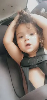 Adorable baby in car seat with a charming expression.