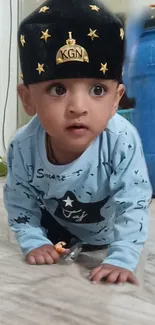 Adorable baby in a blue outfit crawling on the floor, showcasing innocence.