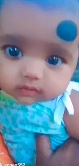 Adorable baby in blue outfit close-up photo.