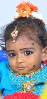 Adorable baby in vibrant attire with expressive eyes.