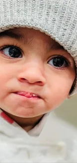 Adorable baby in grey hat with a charming expression.