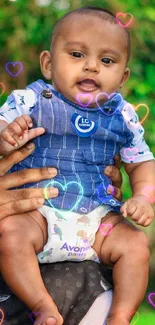 Adorable baby wearing blue denim outfit surrounded by vibrant green nature.