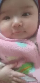 Cute baby in pink outfit smiling at the camera.