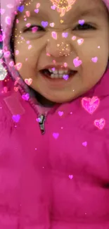 Smiling baby in pink coat with heart overlay.