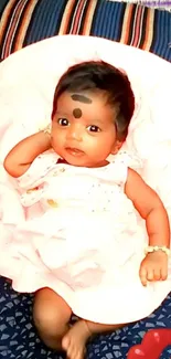 Adorable baby in pink dress on a comfortable background.