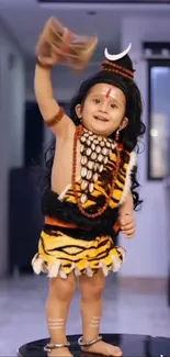 Adorable baby in a tiger-themed costume posing playfully indoors.