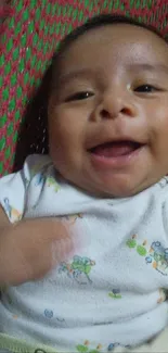 Smiling baby on a colorful woven blanket wallpaper.