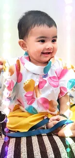 Adorable baby in colorful outfit on a striped brown couch.