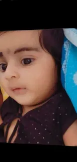 Adorable baby resting peacefully on a colorful blanket.