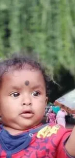 Adorable baby taking a selfie with a green background.