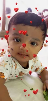 Adorable baby with heart overlay design on mobile wallpaper.