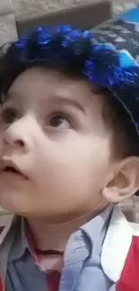 Adorable child in a blue birthday hat.