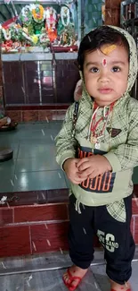 Adorable child stands in colorful temple.